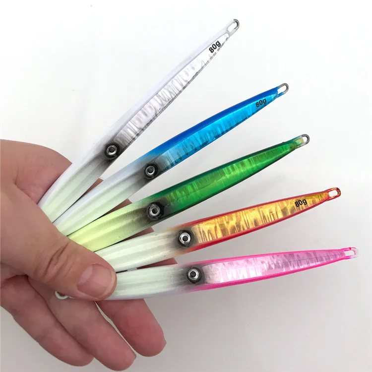 Una persona que sostiene un juego de señuelos de pesca translúcidos y coloridos. Estos señuelos están diseñados para parecerse a los peces y se utilizan para atraer peces cuando se pesca.