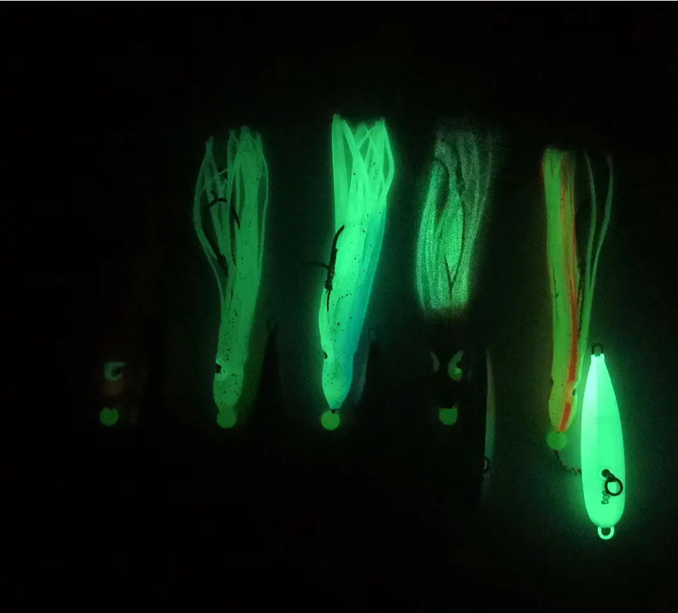 Una colección de señuelos de pesca que brillan en la oscuridad. Estos señuelos están diseñados para emitir un brillo verde, cuyo objetivo es atraer peces en condiciones de poca luz, como la pesca nocturna.