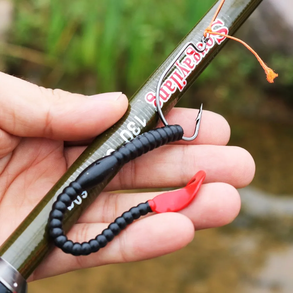 Una persona que sostiene una caña de pescar con un gancho y un señuelo