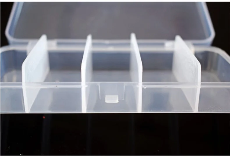 Un recipiente de plástico con tapa transparente y un divisor blanco