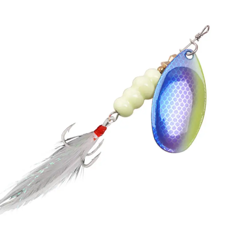 Un señuelo de pesca. Consiste en un anzuelo con una banda roja, una cuenta blanca, un cuerpo de plástico azul y verde y una cola de color plateado o cromado que parece estar hecha de oropel o un material similar.