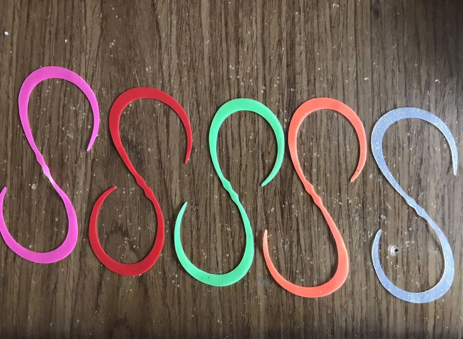 Una fila de anillos de plástico de color en una mesa de madera