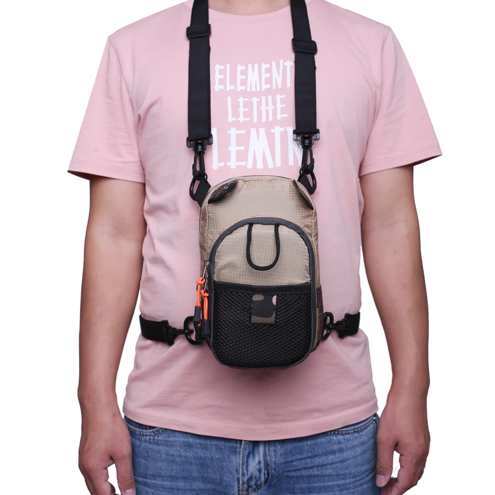 Una persona que llevaba una camiseta rosa con el texto ELEMENT LET THE ELEMENTS impreso. La persona también lleva un bolso cruzado con una correa que pasa por encima del hombro y cruza el pecho.