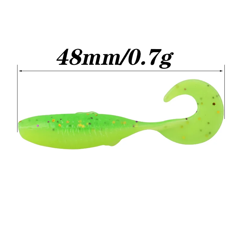 Un señuelo verde, que es un tipo de cebo de pesca artificial diseñado para parecerse a un pez u otra criatura acuática. Tiene una forma curva con una cola que probablemente pretende imitar el movimiento de un pez nadando.