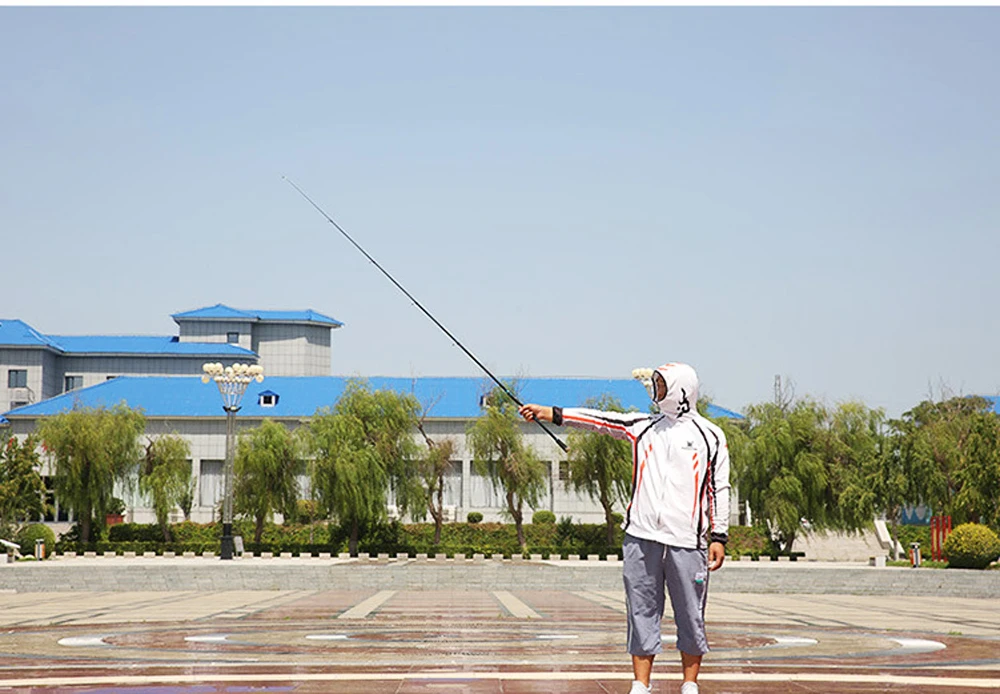 El entusiasta de la pesca disfruta de un día soleado con una caña larga frente a un edificio moderno