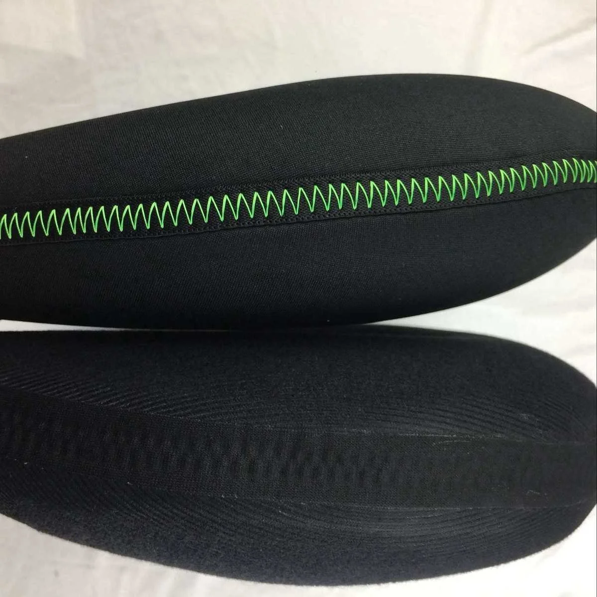 Elegante cojín negro con costuras verdes vibrantes