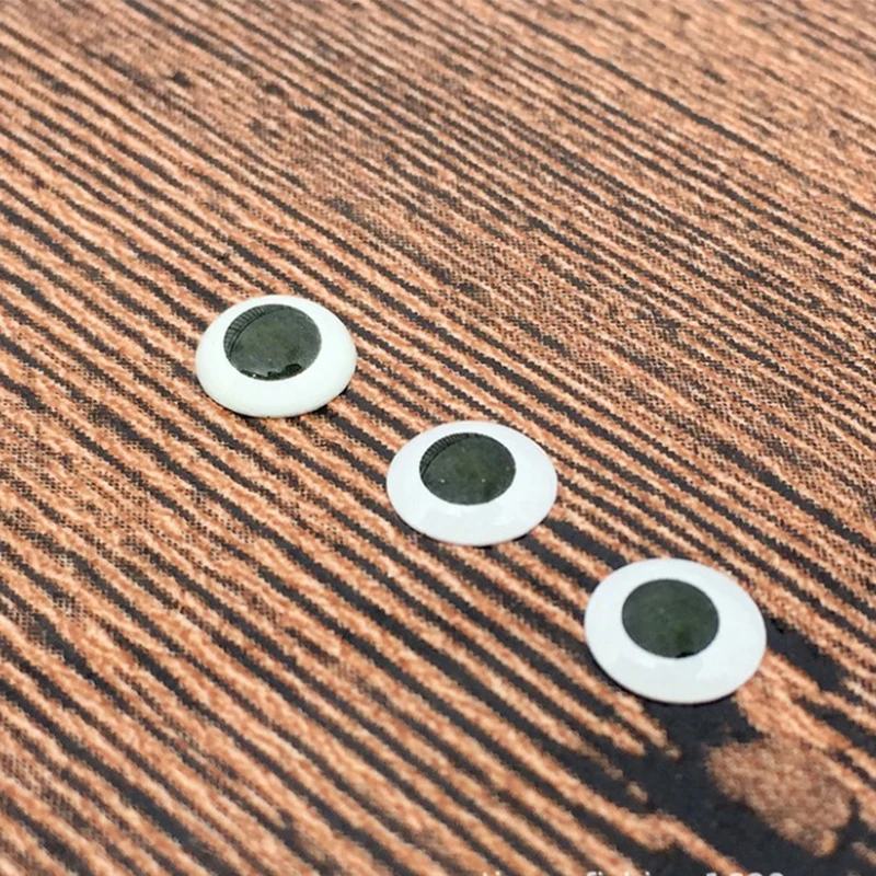 Tres círculos blancos con centros negros están en una superficie de madera