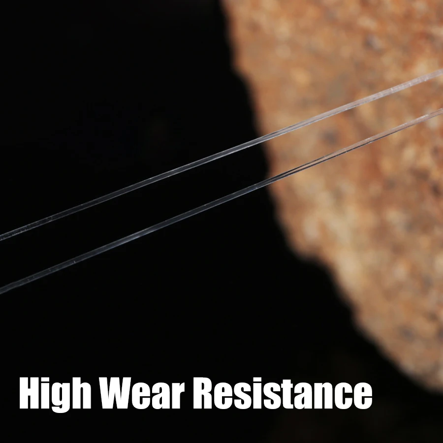 Un primer plano de un material con una alta resistencia al desgaste. Parece ser un objeto delgado y alargado, posiblemente una fibra o un filamento, colocado sobre un fondo oscuro con una superficie texturizada y borrosa que podría ser una roca o un material similar.
