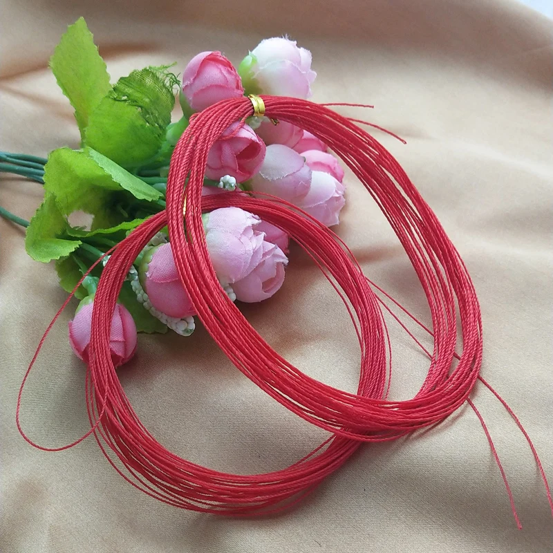 Un vibrante ramo de rosas rosadas combinadas con cuerdas rojas que simbolizan el amor y la prosperidad