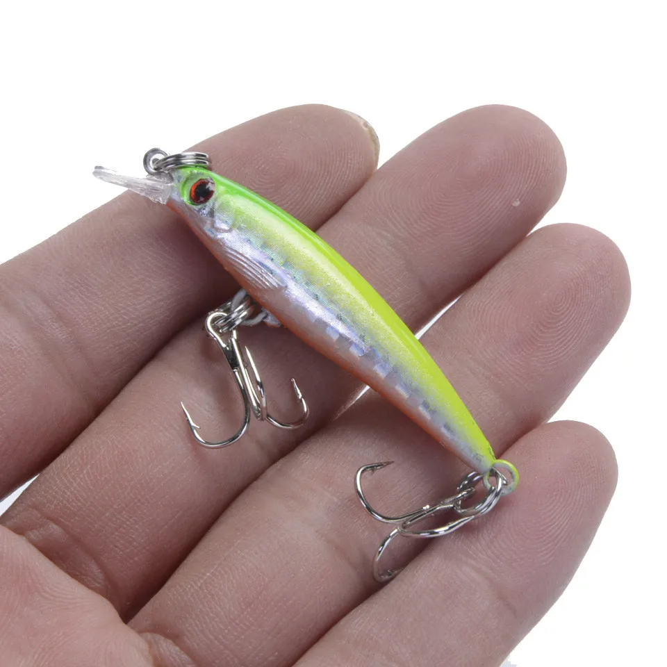 Un pequeño señuelo de pesca de colores brillantes con dos ganchos de agudos