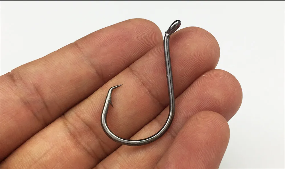 una mano que sostiene un gancho de metal curvo ideal para pescar o manejar