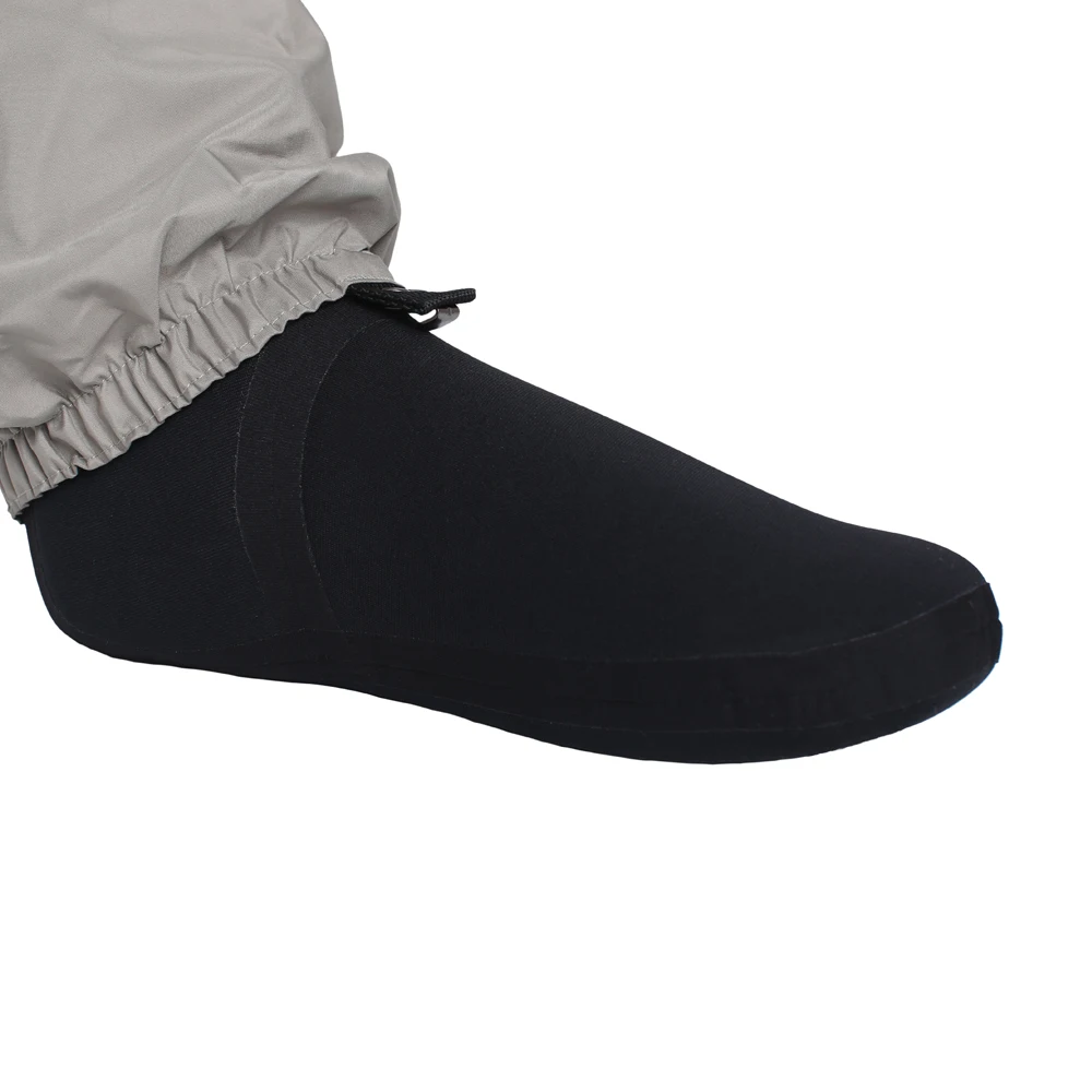 El pie de una persona que lleva un calcetín negro y un zapato negro. El calcetín parece ser un calcetín redondo con un patrón acanalado en la parte superior y el zapato tiene un diseño bajo con punta redondeada.