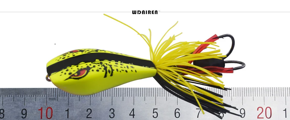Un señuelo, que es un tipo de cebo de pesca diseñado para atraer peces. Este señuelo en particular tiene un cuerpo amarillo con manchas negras, que se asemeja a un pez, y está adornado con materiales parecidos a pelos amarillos y rojos que imitan la apariencia de la cola o las aletas de un pez.