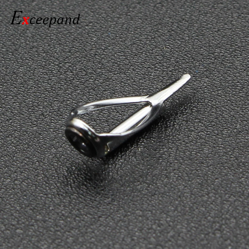 Un pequeño pasador plateado está sentado sobre un fondo negro