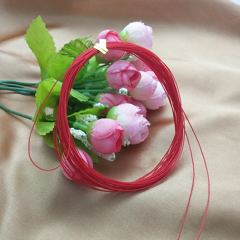 Un vibrante ramo de rosas rosadas con cuerdas rojas que simbolizan el amor y la prosperidad