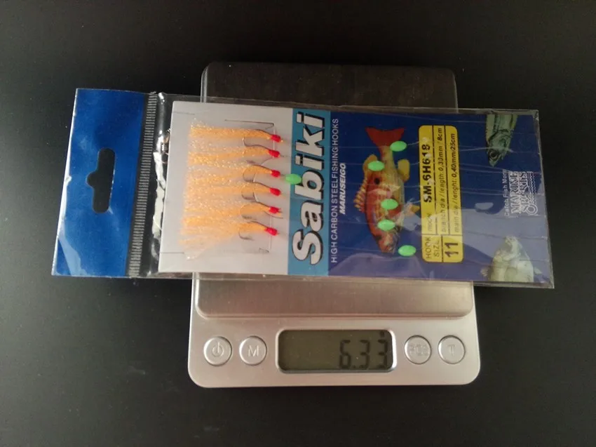 un conjunto de ganchos de pesca con una escala digital que muestra su peso