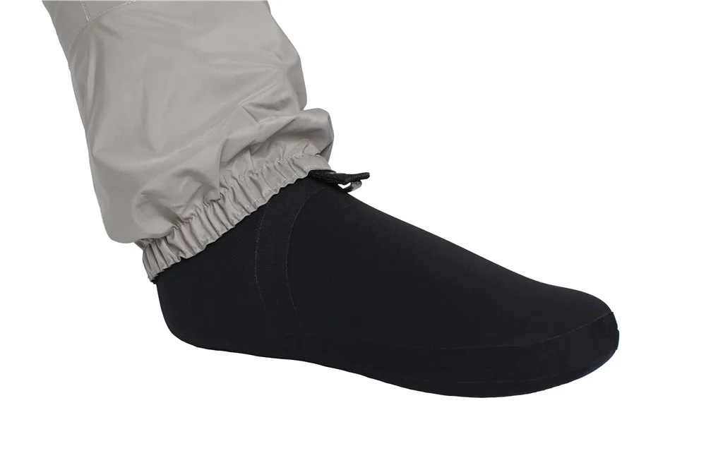 La pierna de una persona que lleva un par de calcetines negros subidos hasta la rodilla. Los calcetines parecen ser de un material grueso, posiblemente térmico o que absorbe la humedad, lo cual es común en calcetines diseñados para brindar calidez o comodidad.