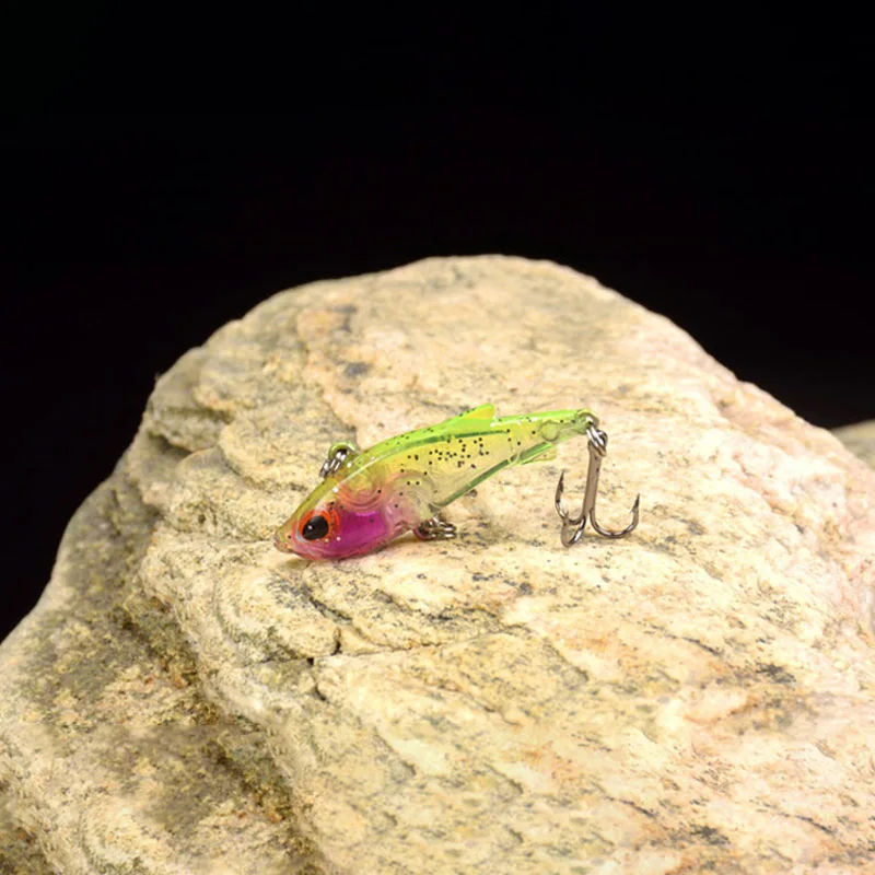 Un vibrante señuelo de pesca llamativo con un diseño único descansa en una roca texturizada