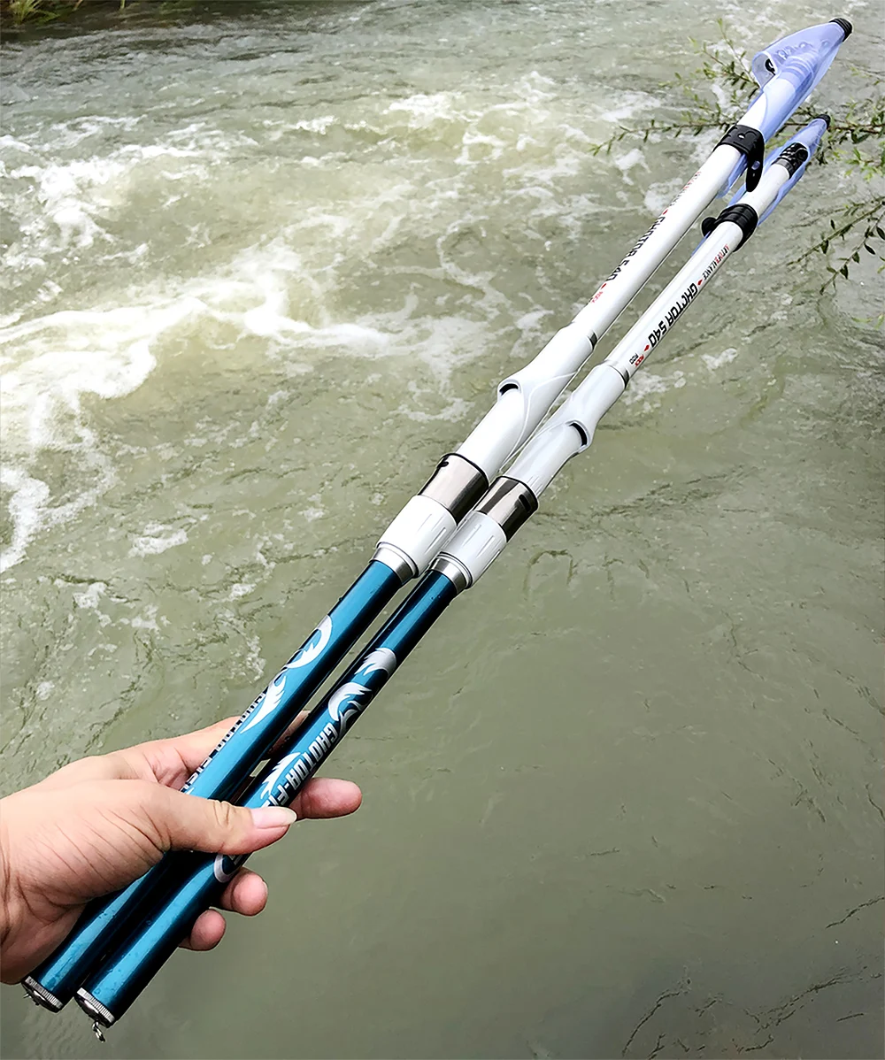 Un par de bastones de esquí sostenidos sobre una masa de agua, que parece ser un río o arroyo con algunos rápidos. Los postes son alargados y tienen una combinación de colores azul y blanco. La persona que sostiene los postes no es visible en la imagen, solo se muestra su mano.