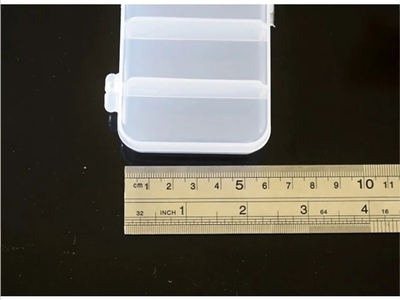 Se está midiendo un recipiente de plástico transparente con una regla