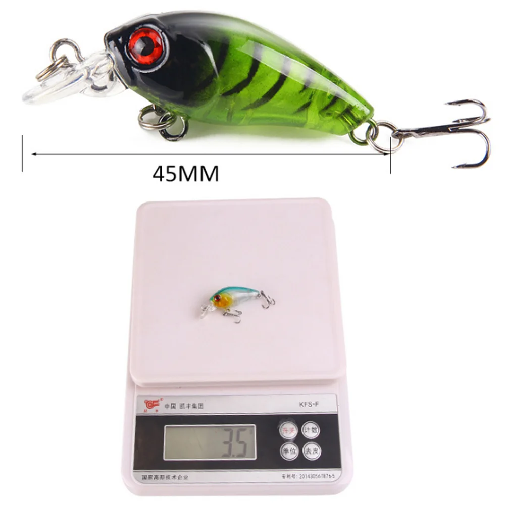 Un señuelo de pesca verde de 45 mm con un gancho y una escala para una medición de peso precisa