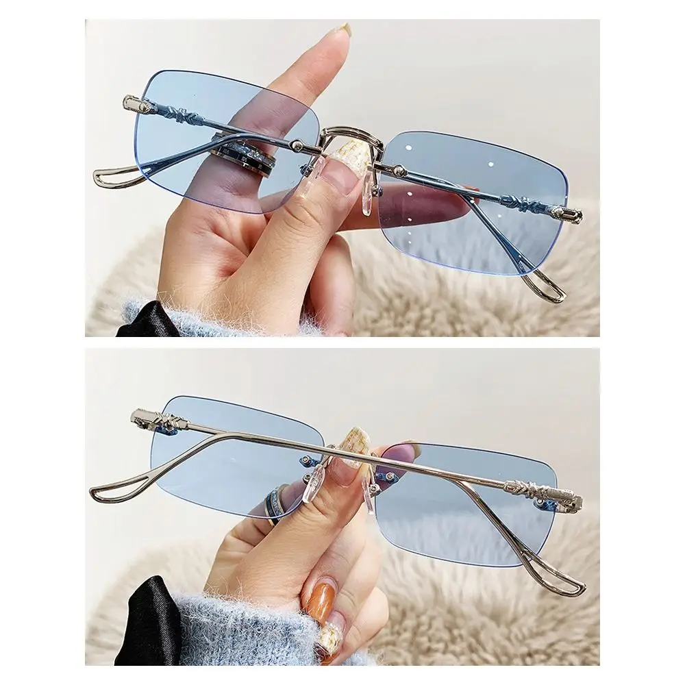 Una mujer sosteniendo un par de gafas de sol en la mano