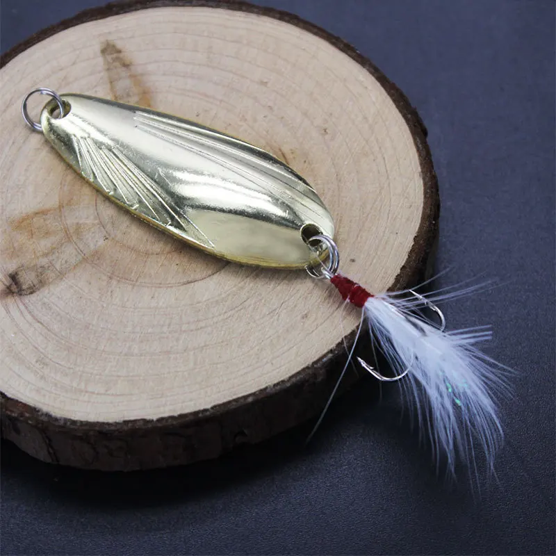 Señuelo de pesca dorada con detalles de plumas para pesca efectiva