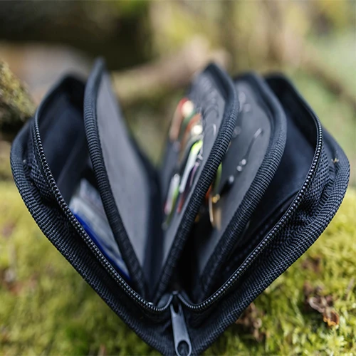 Detalle de los paneles interiores de la bolsa Kylebooker con moscas de pesca sujetas