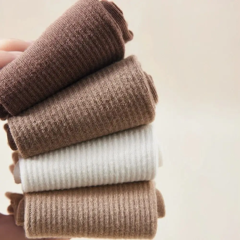 Una pila de calcetines acanalados marrones y blancos que muestran su textura y diseño