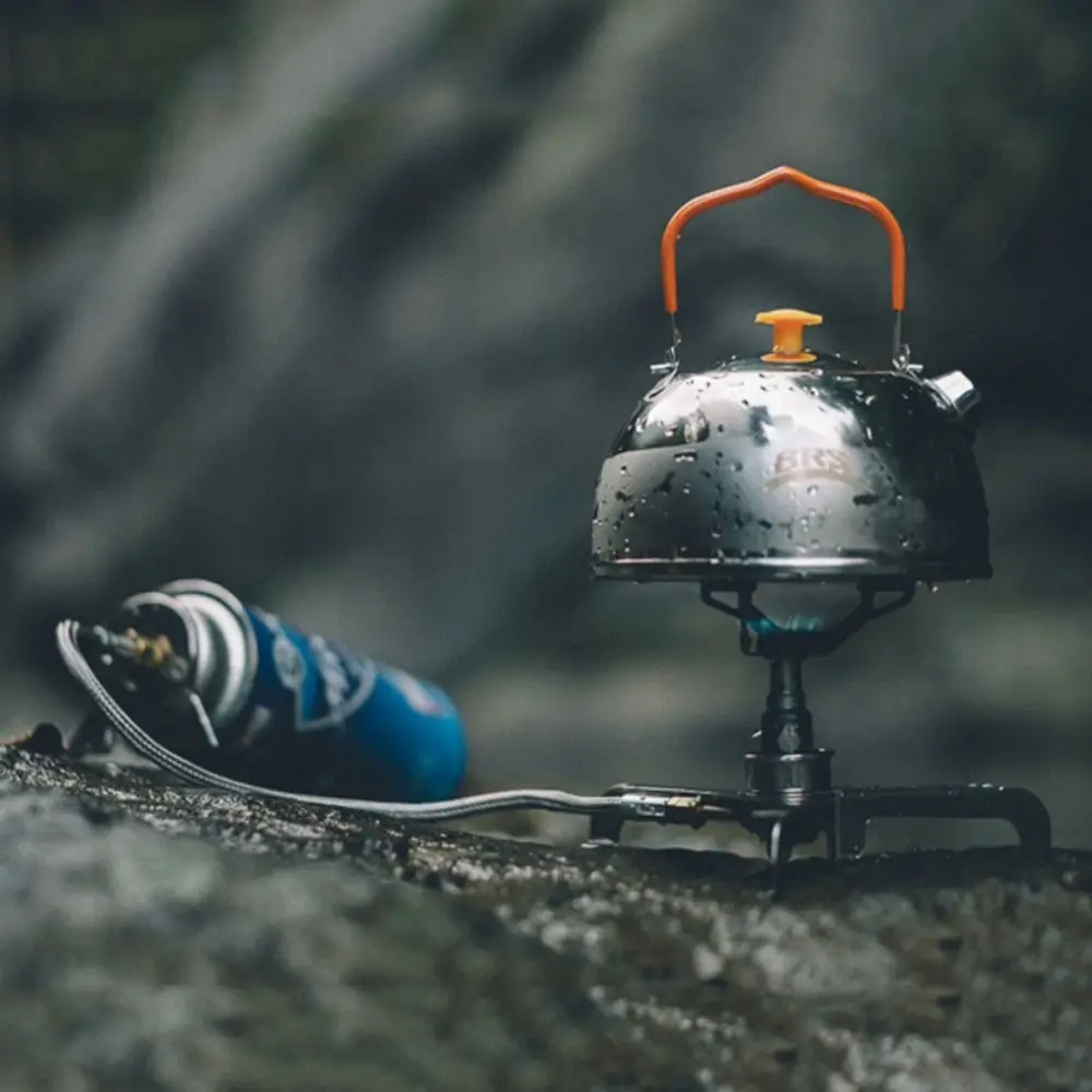 Disfrutando de una acogedora experiencia de campamento al aire libre con una estufa portátil y una botella de agua