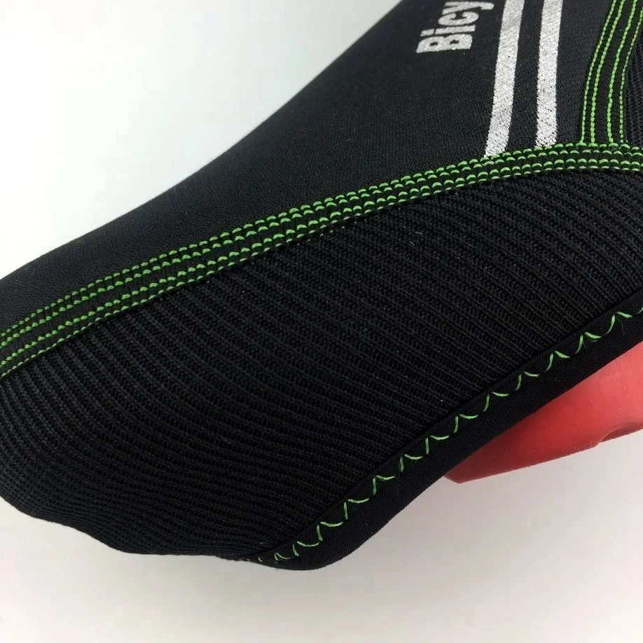 Un primer plano de un sillín de bicicleta negro con un borde verde. El sillín parece estar diseñado para brindar comodidad, con una forma contorneada que sugiere que podría estar destinado a paseos largos o de turismo.