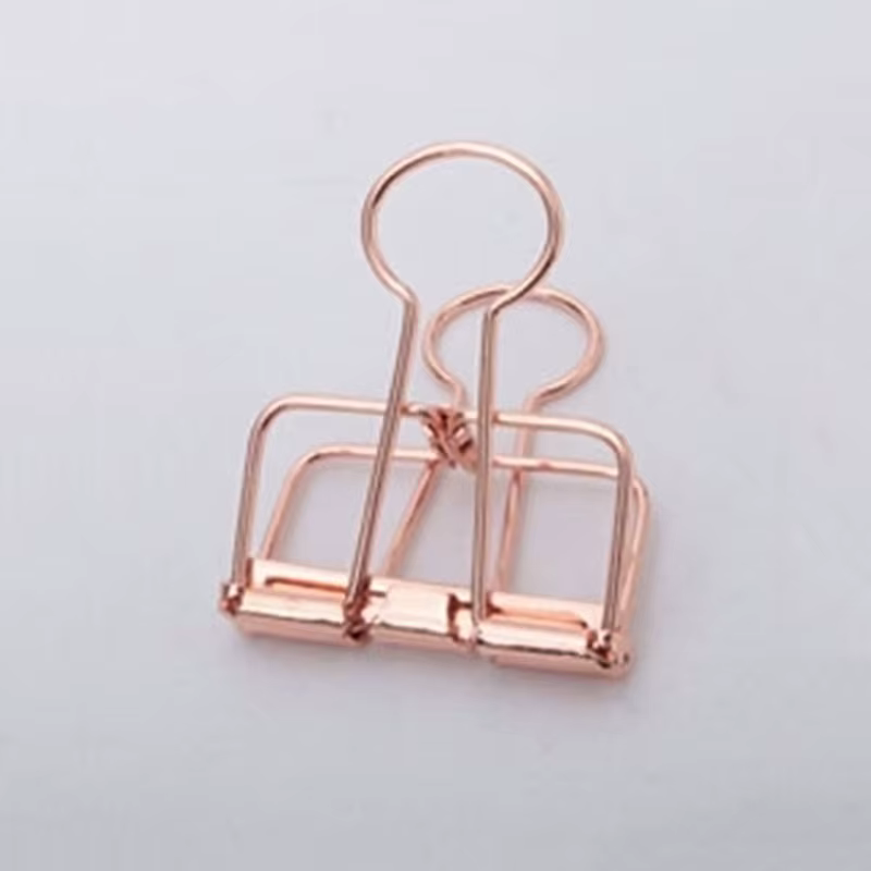 Primer plano de un clip de carpeta de oro rosa resaltando su acabado metálico