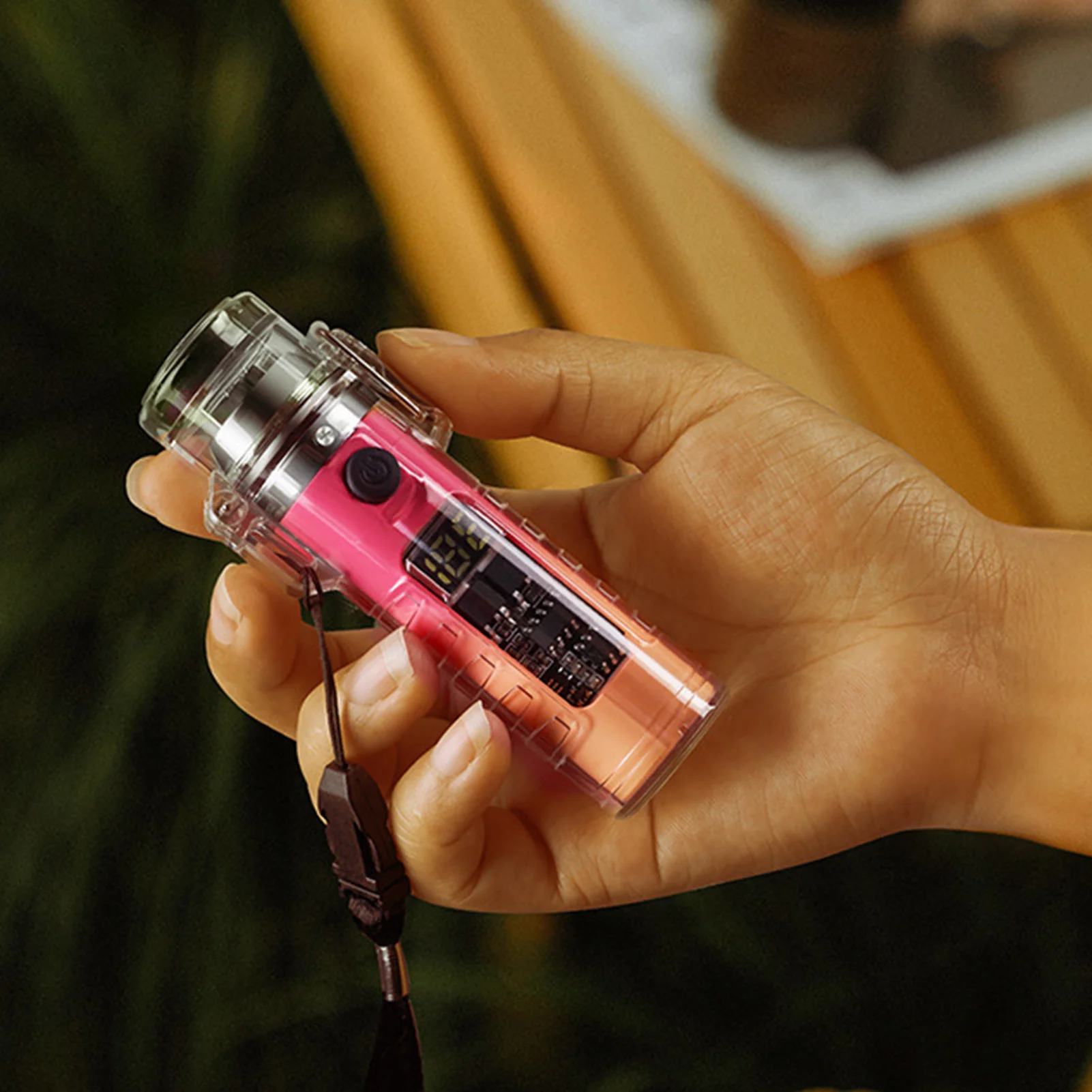 Una persona que sostiene una cámara rosa con correa negra