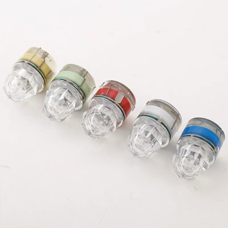 Una fila de cinco bombillas con tapas de diferentes colores