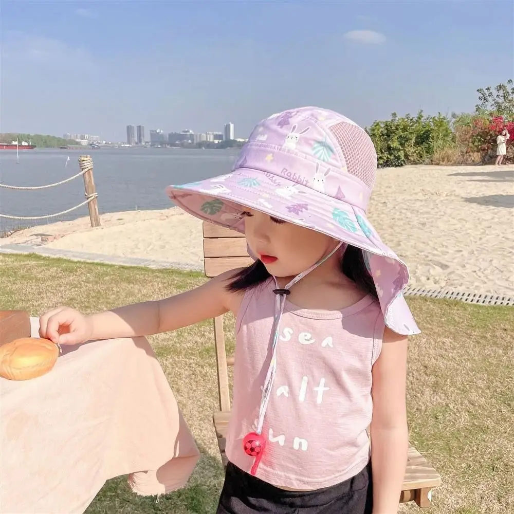 Un niño pequeño disfruta de un día soleado en la playa con un sombrero juguetón y un atuendo divertido