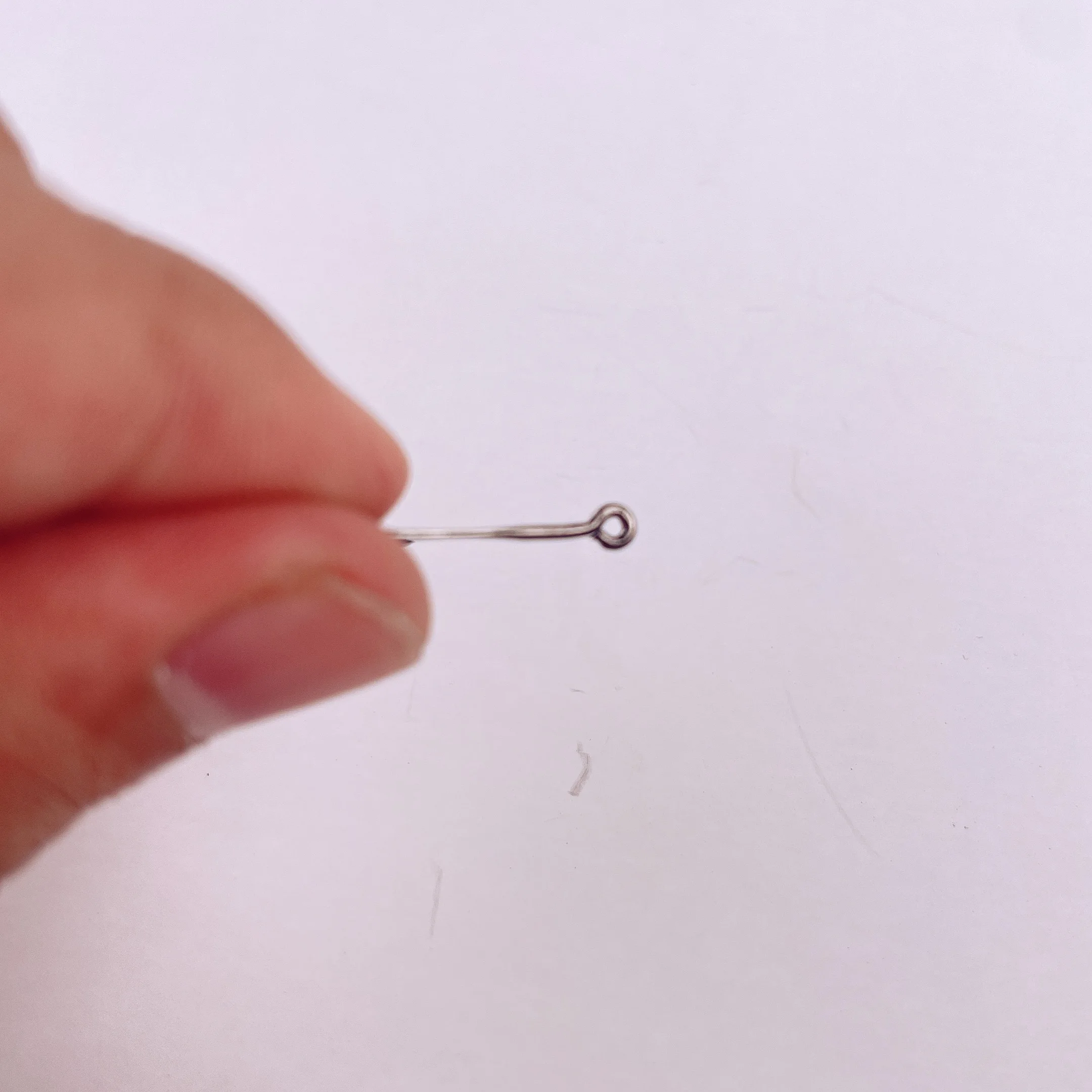 Un pequeño gancho de metal se mantuvo delicadamente entre los dedos