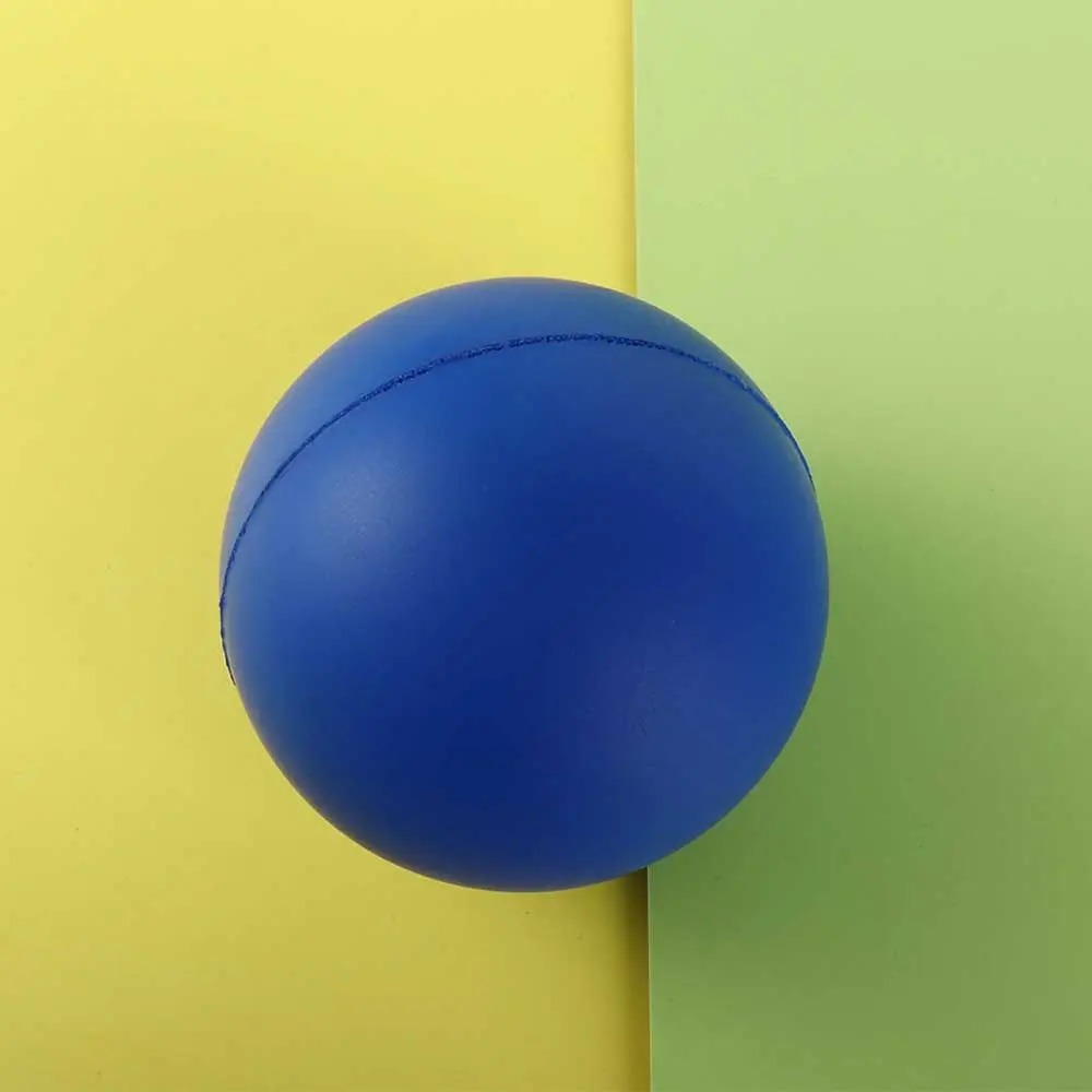 Una bola azul vibrante descansa contra un fondo amarillo y verde dividido que crea un llamativo contraste visual