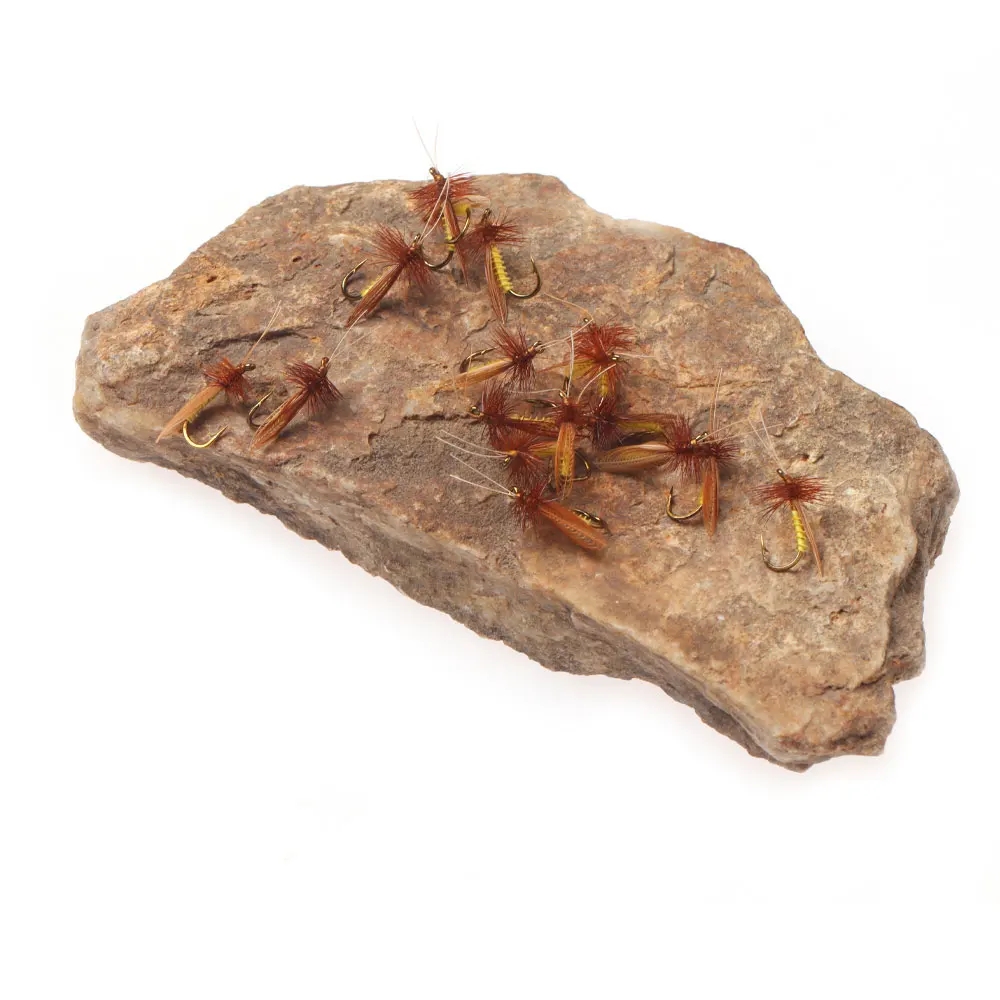 Una selección de moscas de pesca con mosca intrincadamente diseñadas que se exhiben en una superficie de roca natural