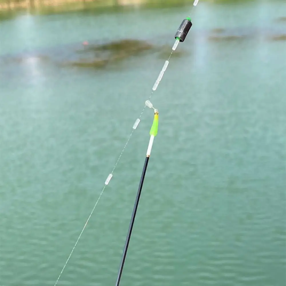 Caña de pescar con un señuelo en el cuerpo de agua sereno