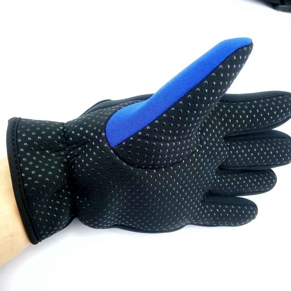 Un par de guantes con una combinación de colores negro y azul. Los guantes tienen un diseño estampado en el dorso de la mano y los dedos están cubiertos con un material negro sólido.