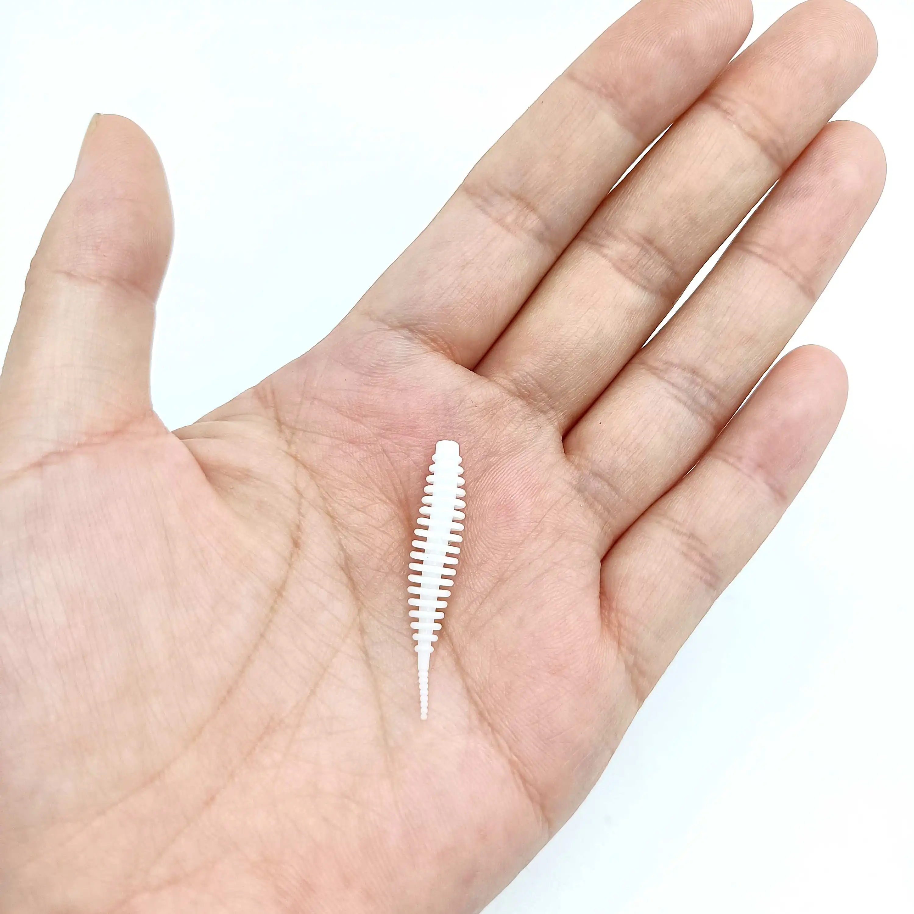 Un pequeño objeto blanco y texturizado descansa en la palma de una mano