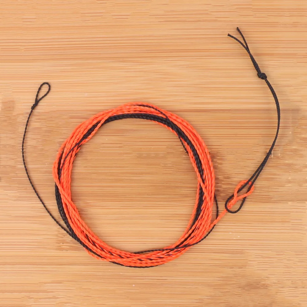 Una bola de hilo naranja en una mesa de madera