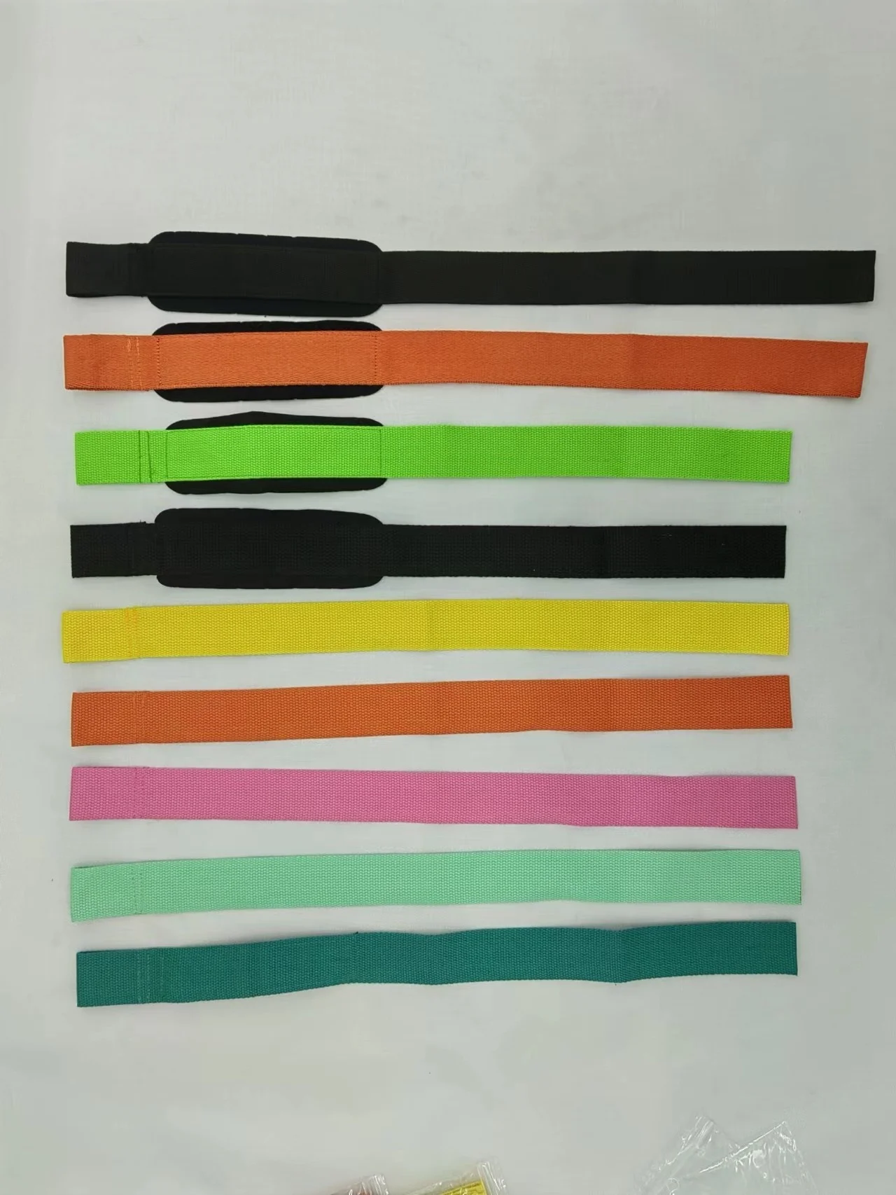 Una colección de bandas o correas de tela de colores. Están dispuestos en fila, cada uno con un color diferente, y parecen tener un ancho uniforme. Estas bandas se pueden utilizar para diversos fines, como accesorios, ropa o como parte de un proyecto artesanal.