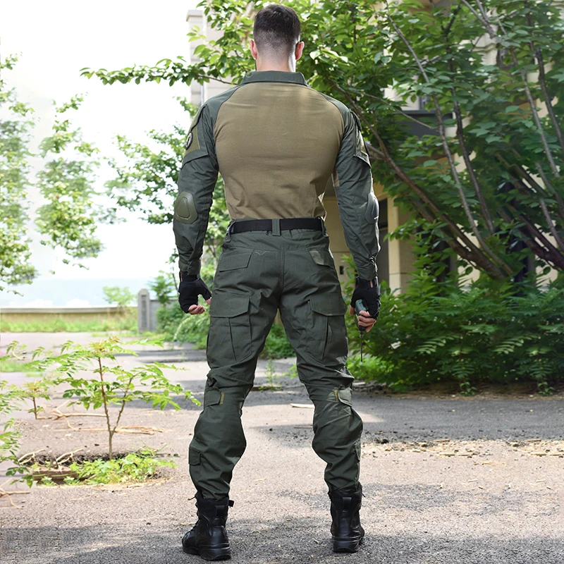 Una persona parada al aire libre. El individuo viste un uniforme de estilo militar, que incluye camisa y pantalón con estampado de camuflaje, cinturón y botas. La persona también lleva guantes y tiene un dispositivo o herramienta en su mano derecha.