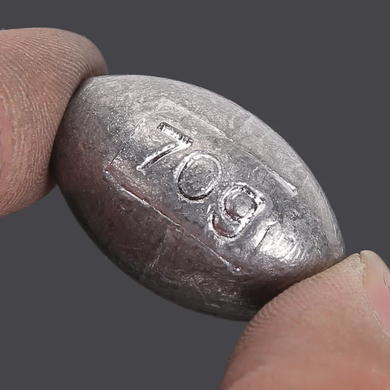 Un objeto metálico con el número '709' grabado en él contenido entre dos dedos