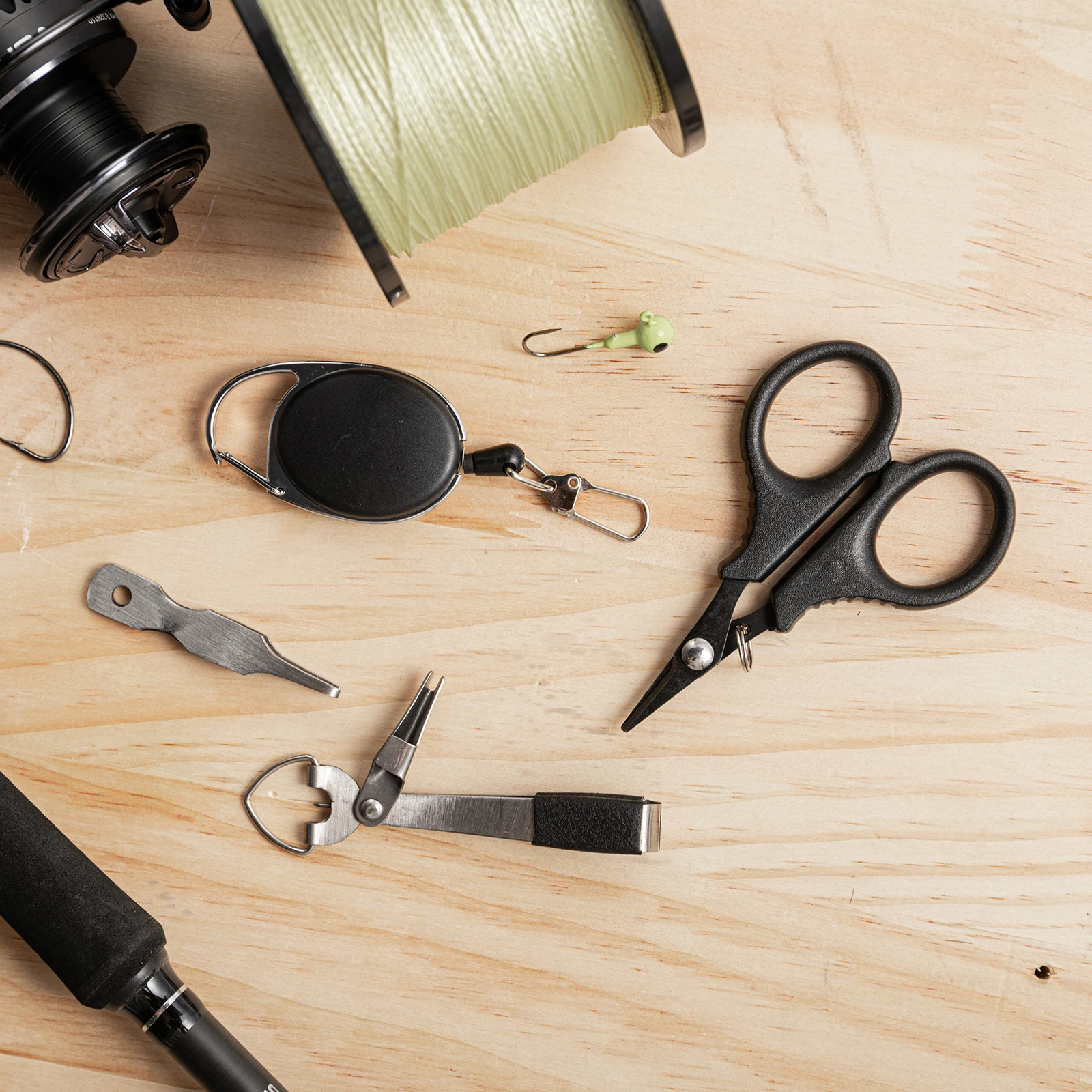 Un par de tijeras y otras herramientas están sobre una mesa.