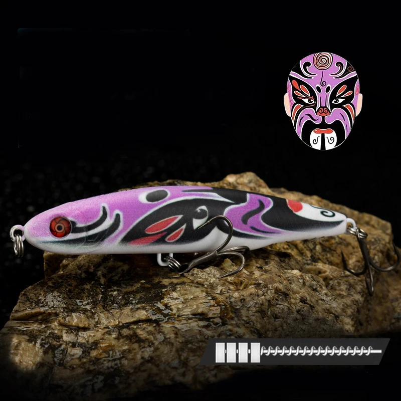 Un señuelo de pesca con un diseño púrpura y rosa está sentado en una roca