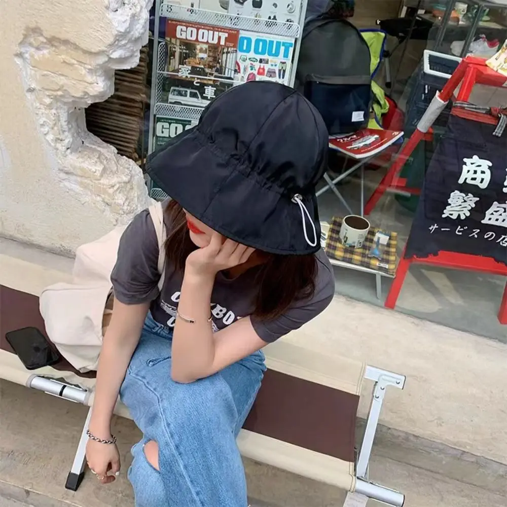 Relajarse al aire libre con un sombrero elegante y un atuendo informal