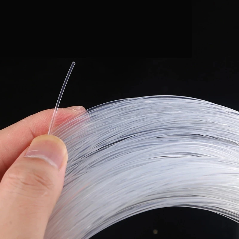 Hilos delgados translúcidos de material sostenidos delicadamente en la mano