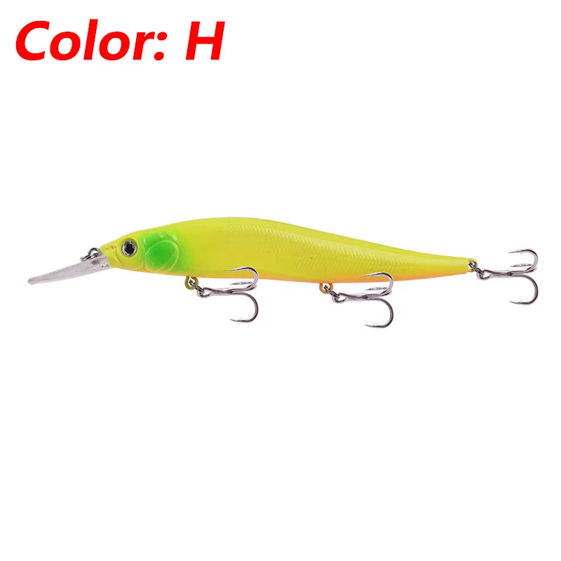 Un señuelo, que es un tipo de cebo de pesca diseñado para atraer peces. Este señuelo en particular es un cebo de plástico blando que se asemeja a un pez y que se utiliza a menudo en la pesca de lubina. Tiene un cuerpo amarillo con una cabeza verdosa y está equipado con un gancho en el extremo de la cola.